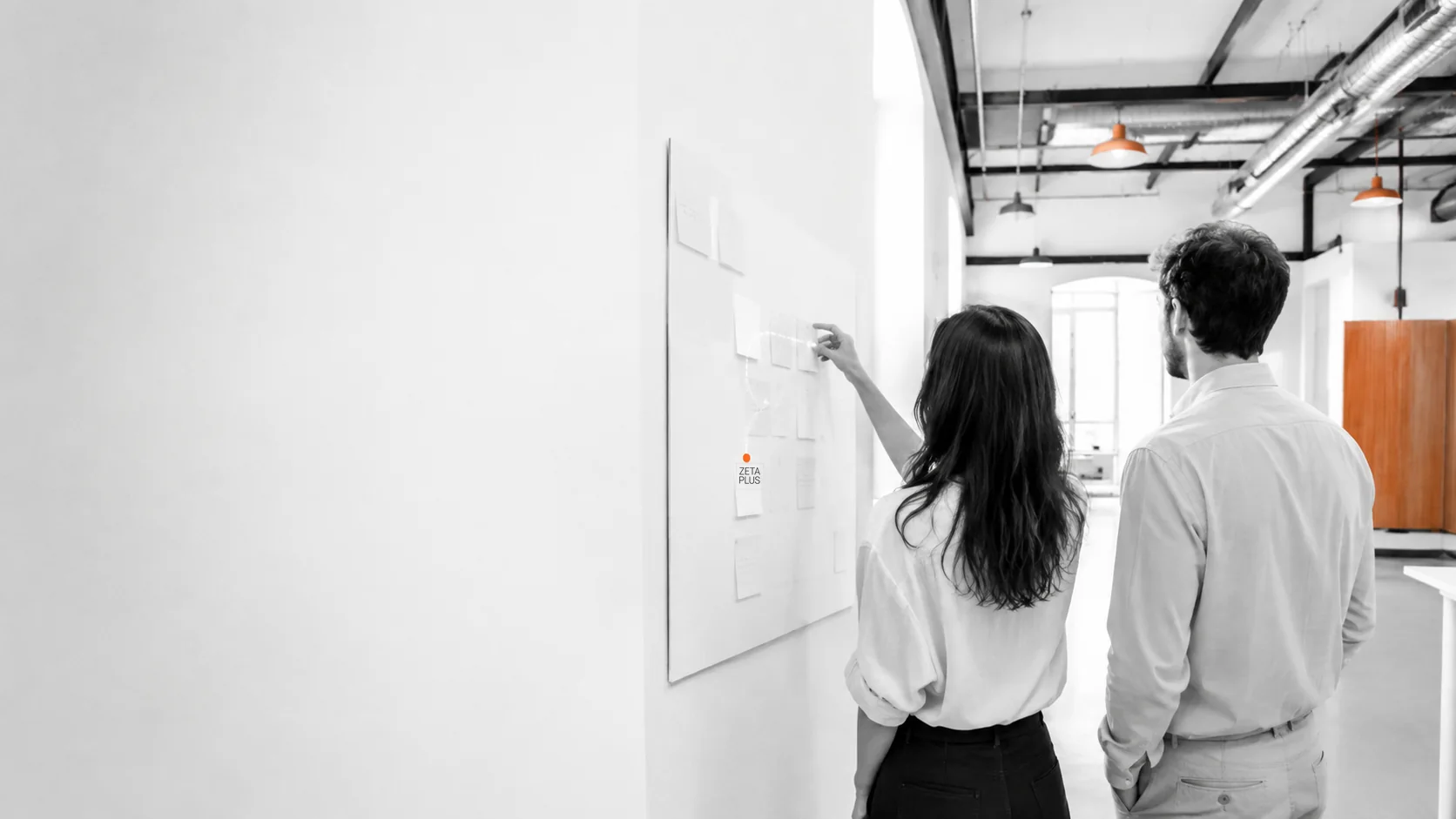Dos personas conversan de pie en las oficinas de ZetaPlus